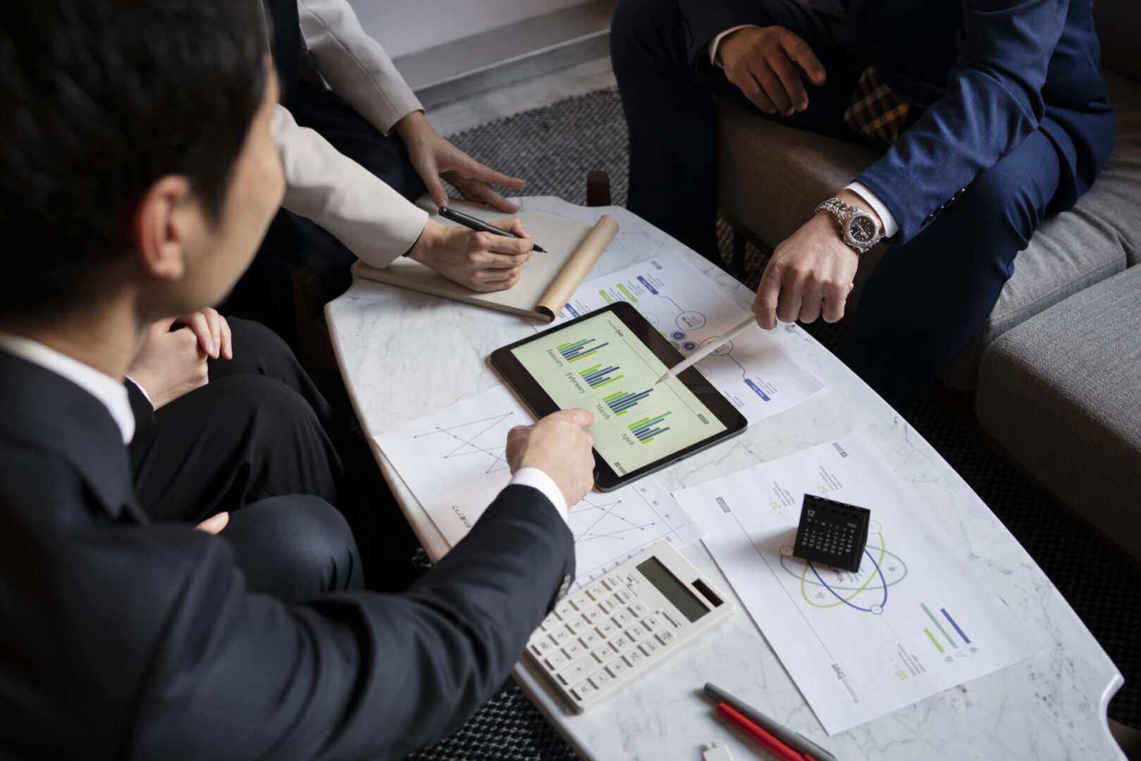 business-people-working-with-ipad-high-angle The Parallel Partnership LLC