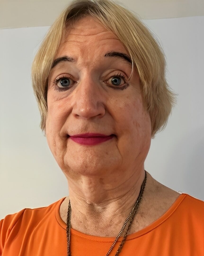 person-3 A woman with blonde hair and wearing an orange shirt.
