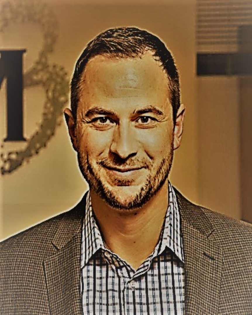 M3 Valenti (1) A man in a suit and tie smiling for the camera.